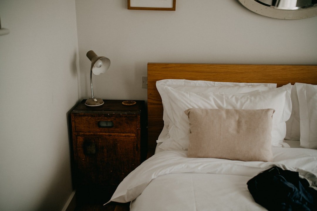 A neatly prepared bed and bedside lamp ready for the first night home after travel.