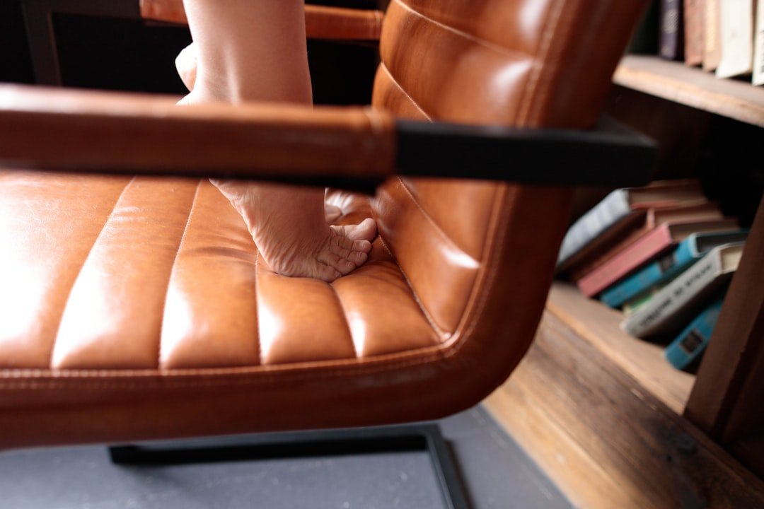 Bare feet standing on a leather chair