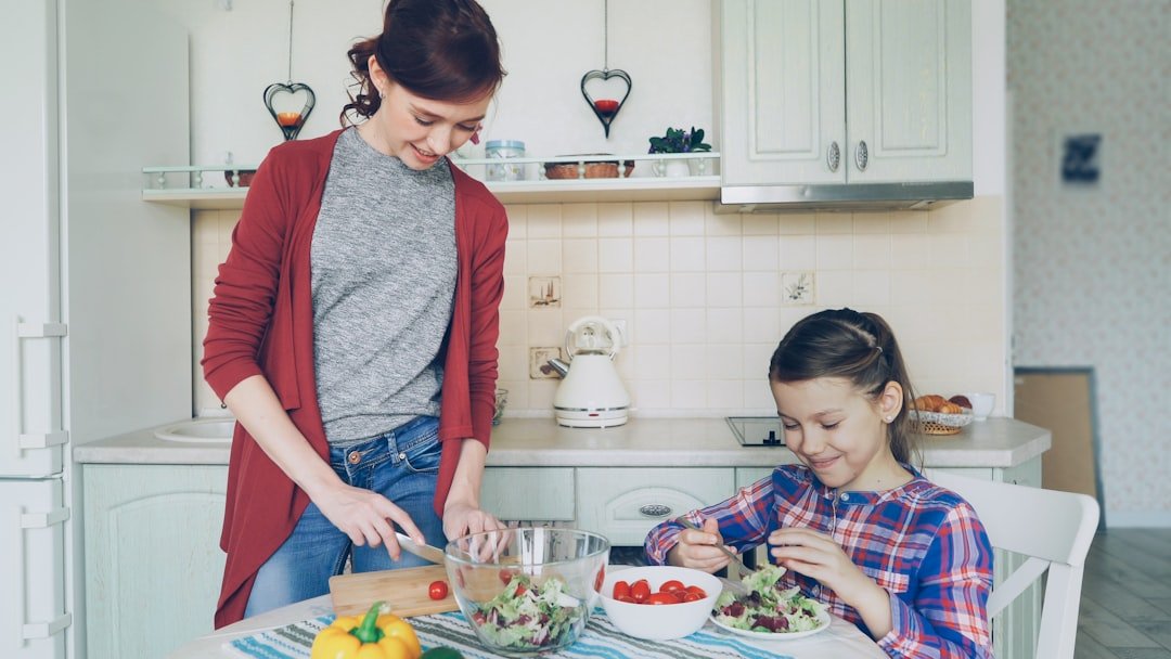 family preparing salad in a bright kitchen