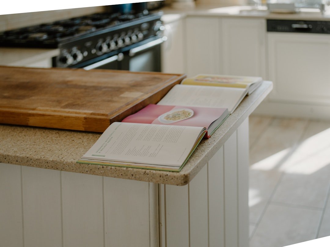 Open cookbooks rest on a kitchen counter.